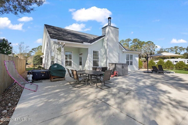 rear view of property featuring a patio area and a hot tub