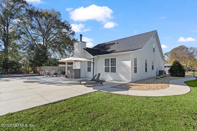 rear view of property featuring a lawn and a patio