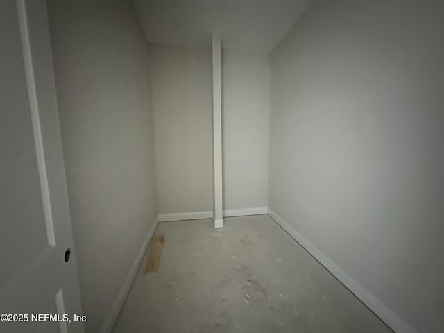 additional living space featuring baseboards and unfinished concrete floors