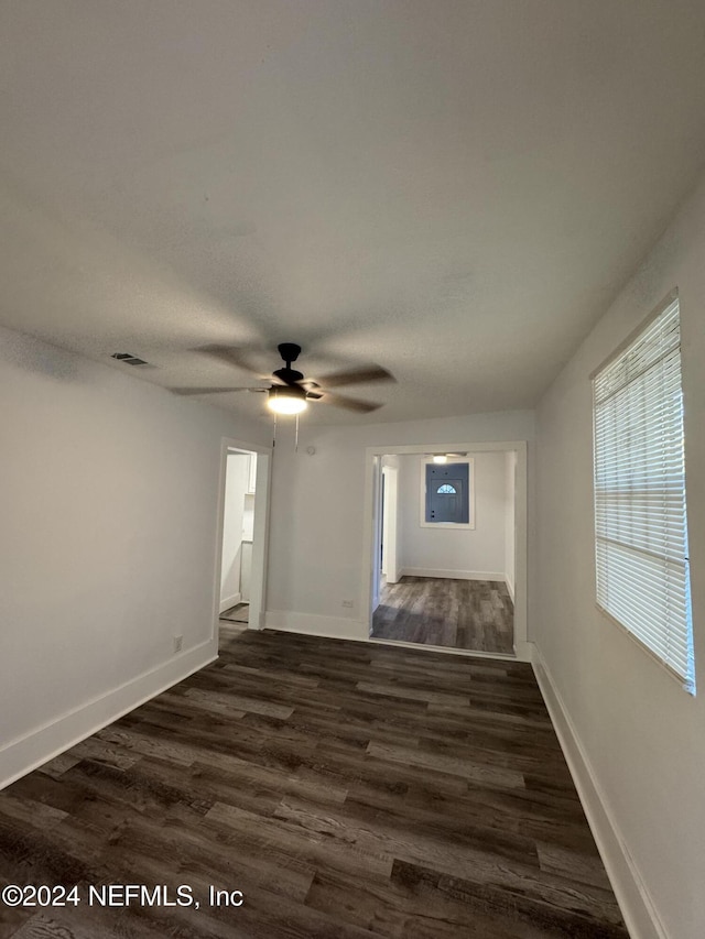 empty room with dark hardwood / wood-style flooring and ceiling fan