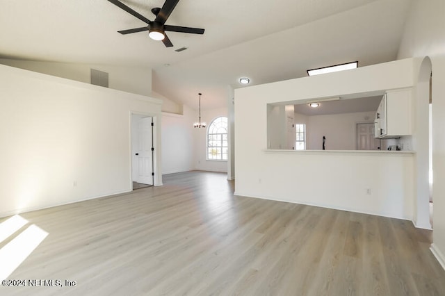 unfurnished living room with ceiling fan with notable chandelier, lofted ceiling, and light hardwood / wood-style flooring