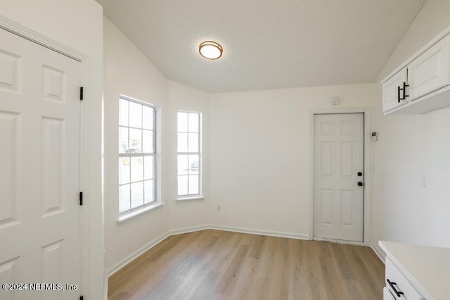 entrance foyer with light wood-type flooring and vaulted ceiling