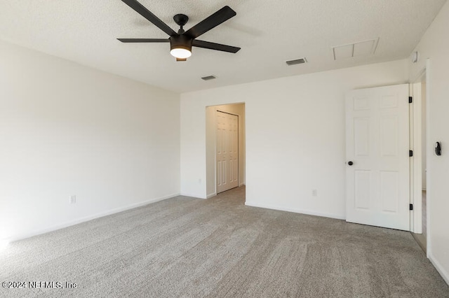 carpeted empty room with ceiling fan and a textured ceiling