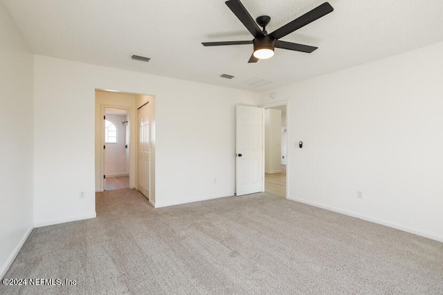 spare room featuring ceiling fan and light colored carpet