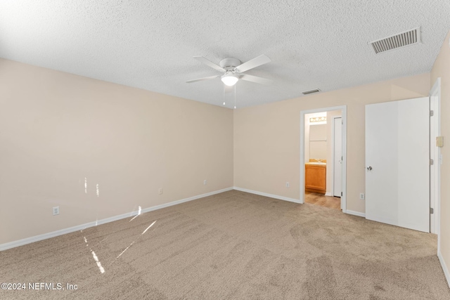 unfurnished room featuring a textured ceiling, ceiling fan, and light carpet