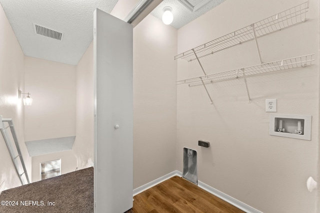 clothes washing area with electric dryer hookup, washer hookup, a textured ceiling, and dark wood-type flooring