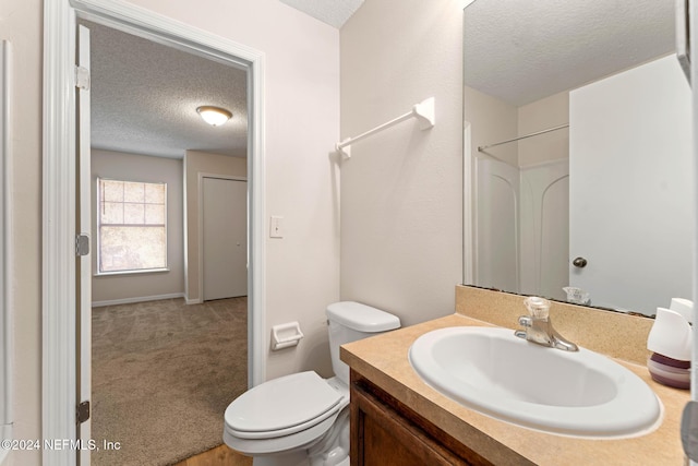 bathroom featuring vanity, a shower, a textured ceiling, and toilet