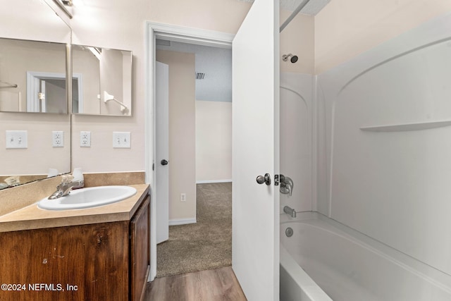 bathroom featuring bathtub / shower combination, hardwood / wood-style floors, and vanity