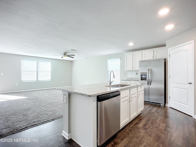 kitchen with stainless steel appliances, a kitchen island with sink, white cabinetry, and sink