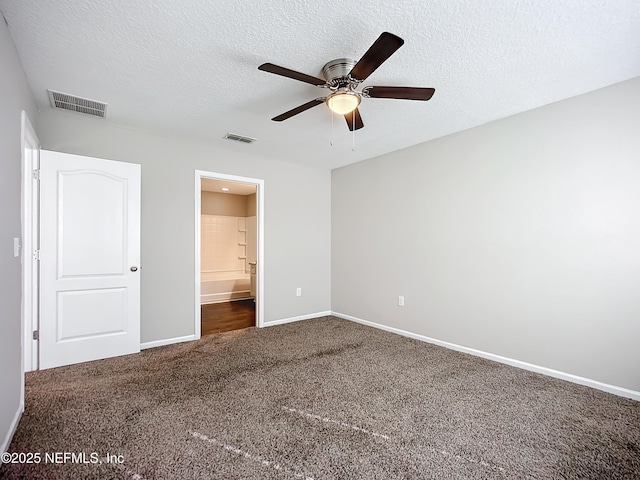 unfurnished bedroom featuring ensuite bath, a textured ceiling, ceiling fan, and carpet