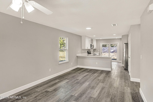 interior space with white cabinetry, sink, dark hardwood / wood-style flooring, and kitchen peninsula