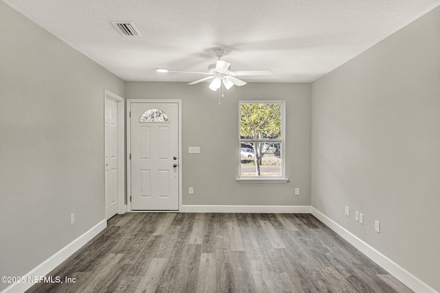 interior space featuring ceiling fan, wood-type flooring, and a textured ceiling