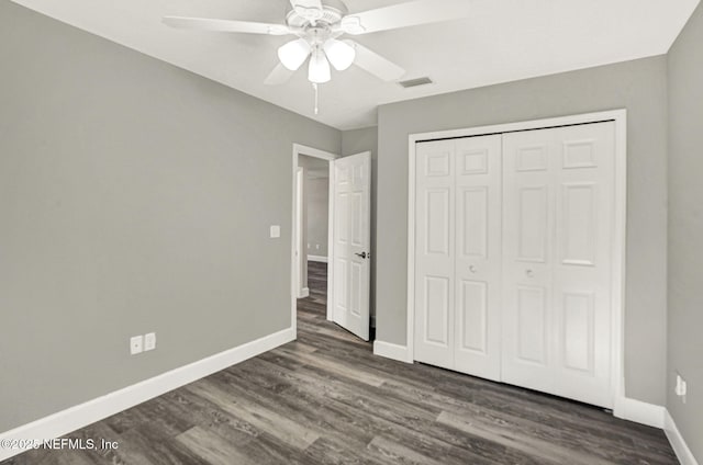 unfurnished bedroom with ceiling fan, dark hardwood / wood-style flooring, and a closet