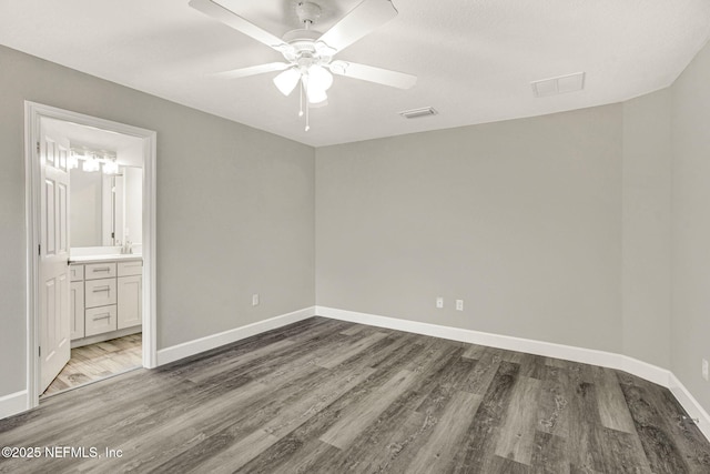 unfurnished bedroom with ceiling fan, hardwood / wood-style floors, and ensuite bath