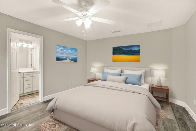 bedroom with wood-type flooring, ceiling fan, and ensuite bath