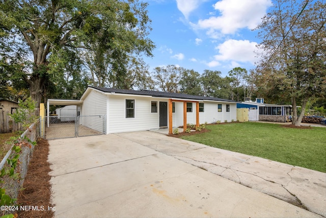 view of front of house with a front yard and a carport