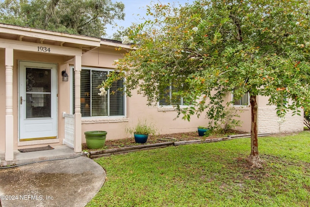 property entrance featuring a lawn