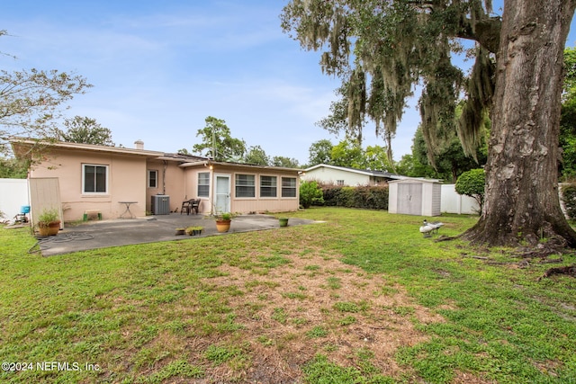 rear view of house with a shed, a lawn, a patio area, and central air condition unit