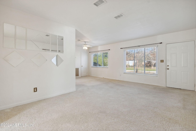 unfurnished living room featuring light carpet and ceiling fan