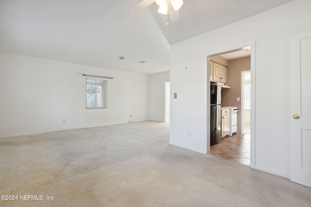 spare room featuring ceiling fan and light carpet