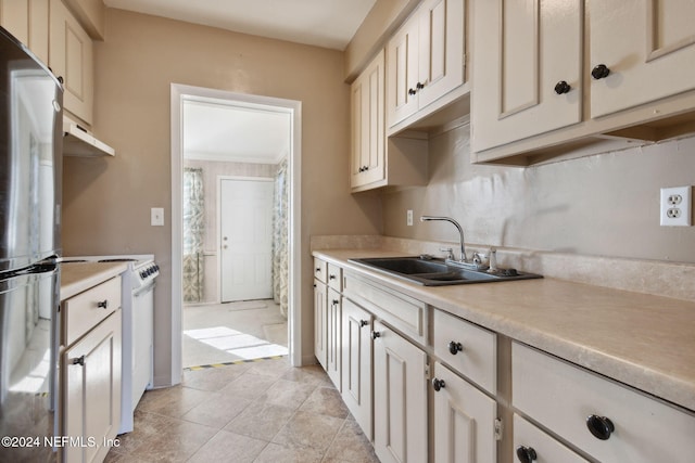 kitchen with range, stainless steel refrigerator, and sink