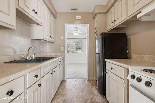 kitchen featuring ceiling fan, sink, light colored carpet, white cabinets, and white stove