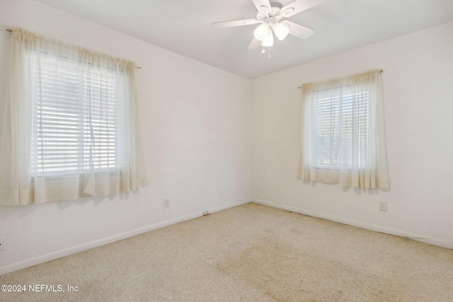 unfurnished room with ceiling fan and carpet