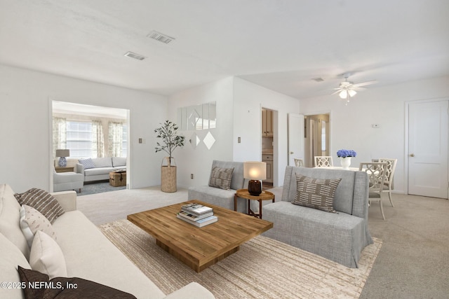 carpeted living room with ceiling fan