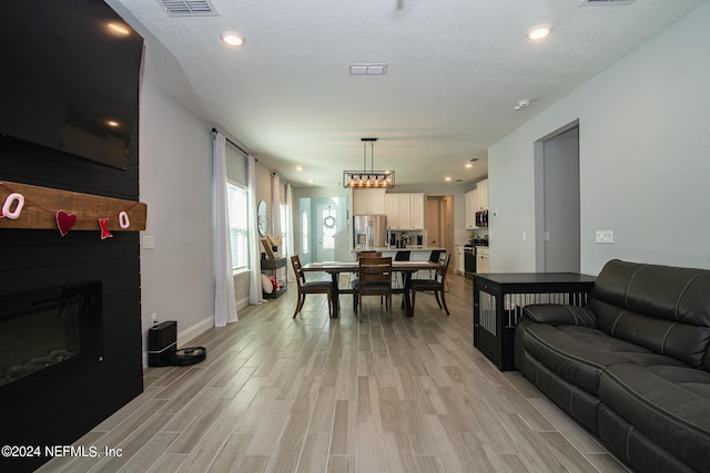 living room featuring light hardwood / wood-style floors and a textured ceiling