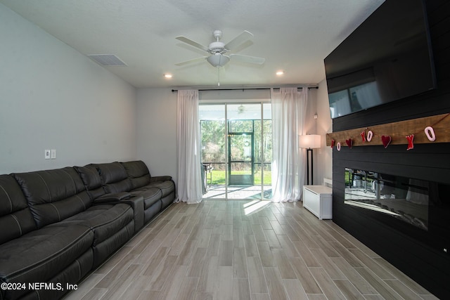 living room with ceiling fan and light hardwood / wood-style flooring