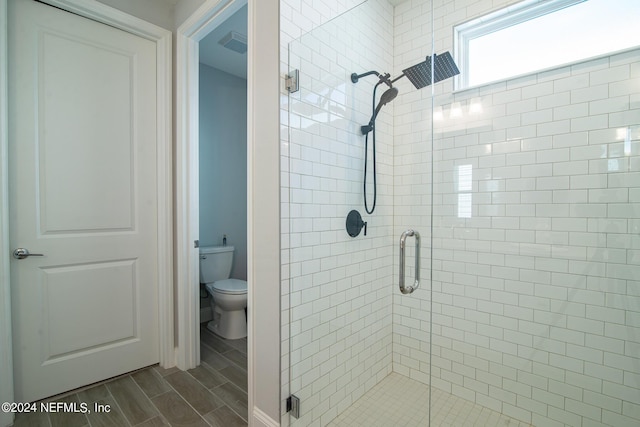 bathroom featuring walk in shower and toilet