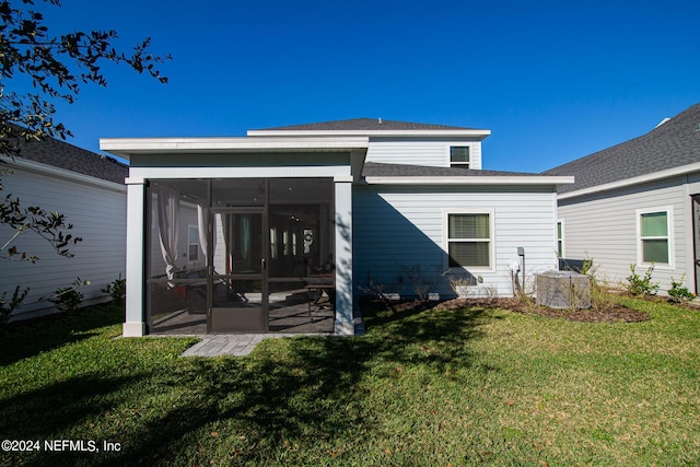 rear view of house featuring a sunroom, a yard, and central air condition unit