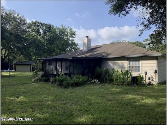 rear view of house featuring a yard