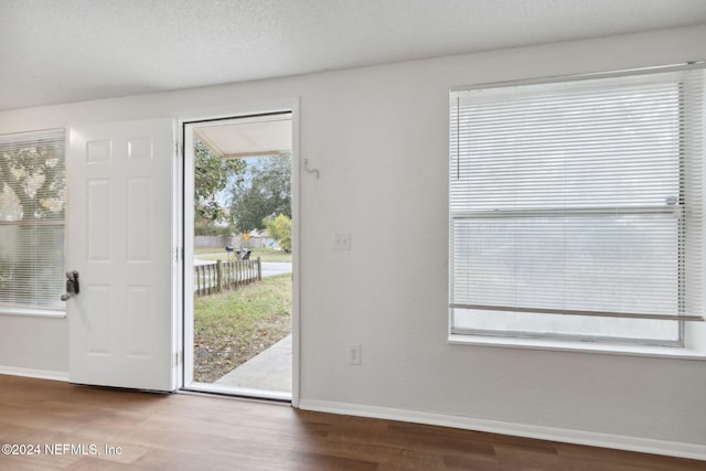 doorway to outside featuring hardwood / wood-style flooring and a textured ceiling