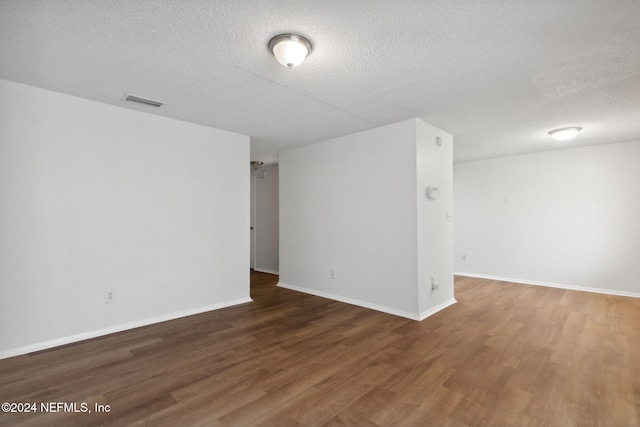 empty room featuring dark hardwood / wood-style flooring and a textured ceiling