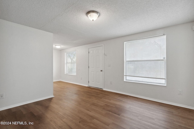 unfurnished room featuring dark hardwood / wood-style floors and a textured ceiling