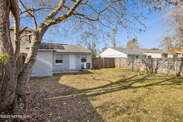 back of house featuring a yard and central AC