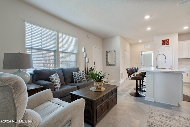 living room featuring light tile patterned flooring and sink