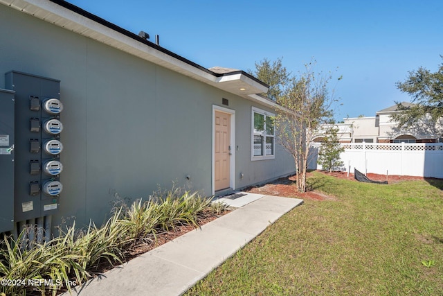 property entrance with a lawn