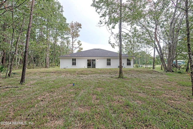 back of property with a lawn