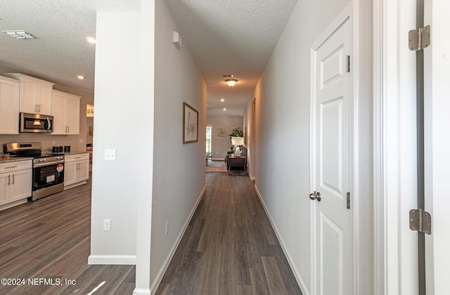 hall featuring a textured ceiling and dark hardwood / wood-style floors