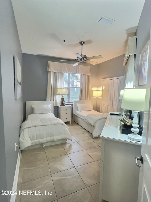 bedroom with ceiling fan, a closet, and light tile patterned floors