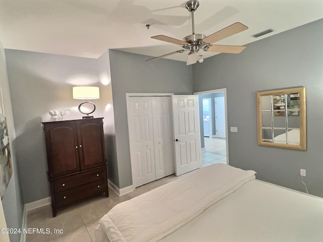 bedroom with ceiling fan, a closet, and light tile patterned floors