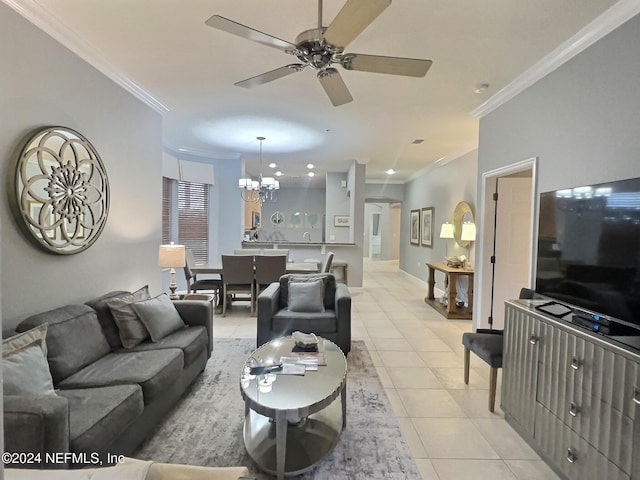 tiled living room with ceiling fan with notable chandelier and ornamental molding