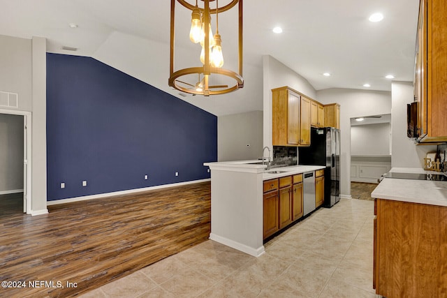 kitchen with vaulted ceiling, hanging light fixtures, appliances with stainless steel finishes, and a chandelier