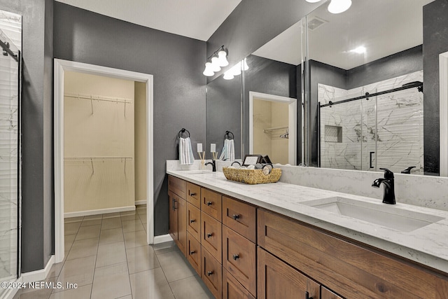 bathroom with tile patterned flooring, vanity, and a shower with door