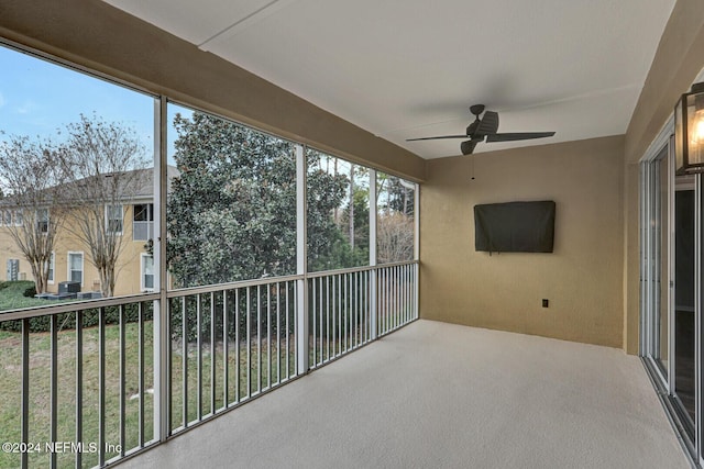 unfurnished sunroom with ceiling fan