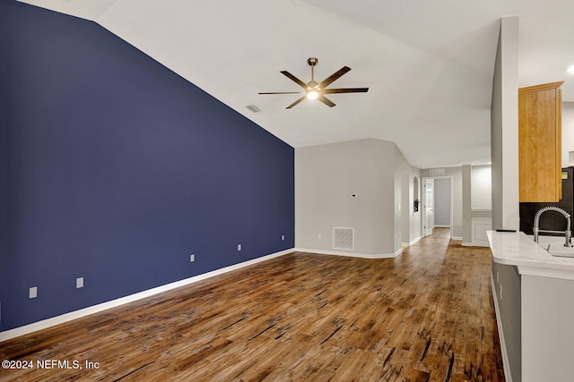 unfurnished living room with hardwood / wood-style flooring, ceiling fan, lofted ceiling, and sink