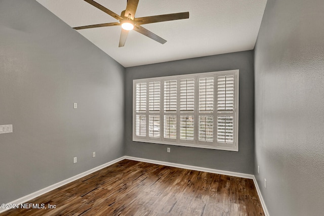 spare room with ceiling fan, dark hardwood / wood-style floors, and vaulted ceiling