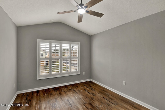 empty room with a textured ceiling, ceiling fan, lofted ceiling, and dark wood-type flooring